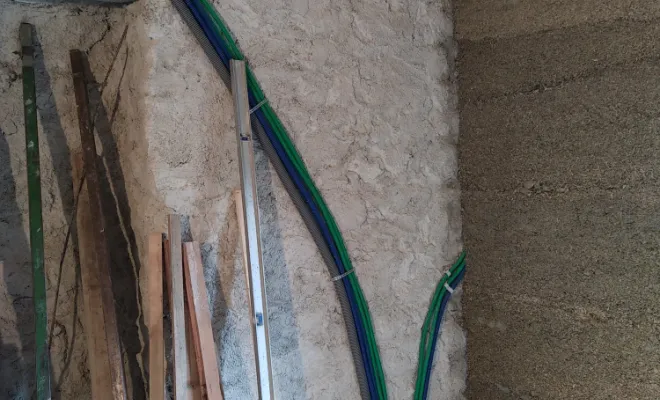 Mur en pierre renforcé avec un gobetis à la chaux. Et installation des réseaux électricité et plomberie